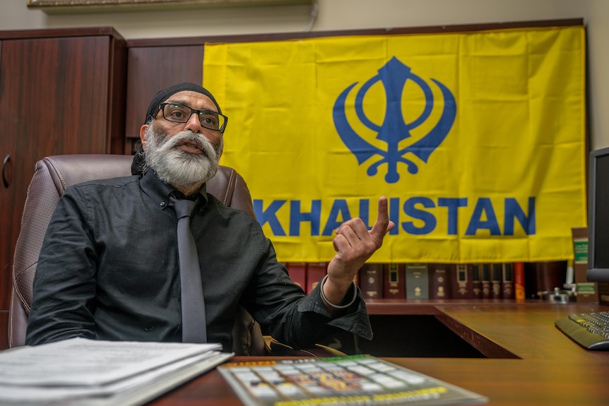 Gurpatwant Singh Pannun sits next to a yellow flag that says 'Khalistan'