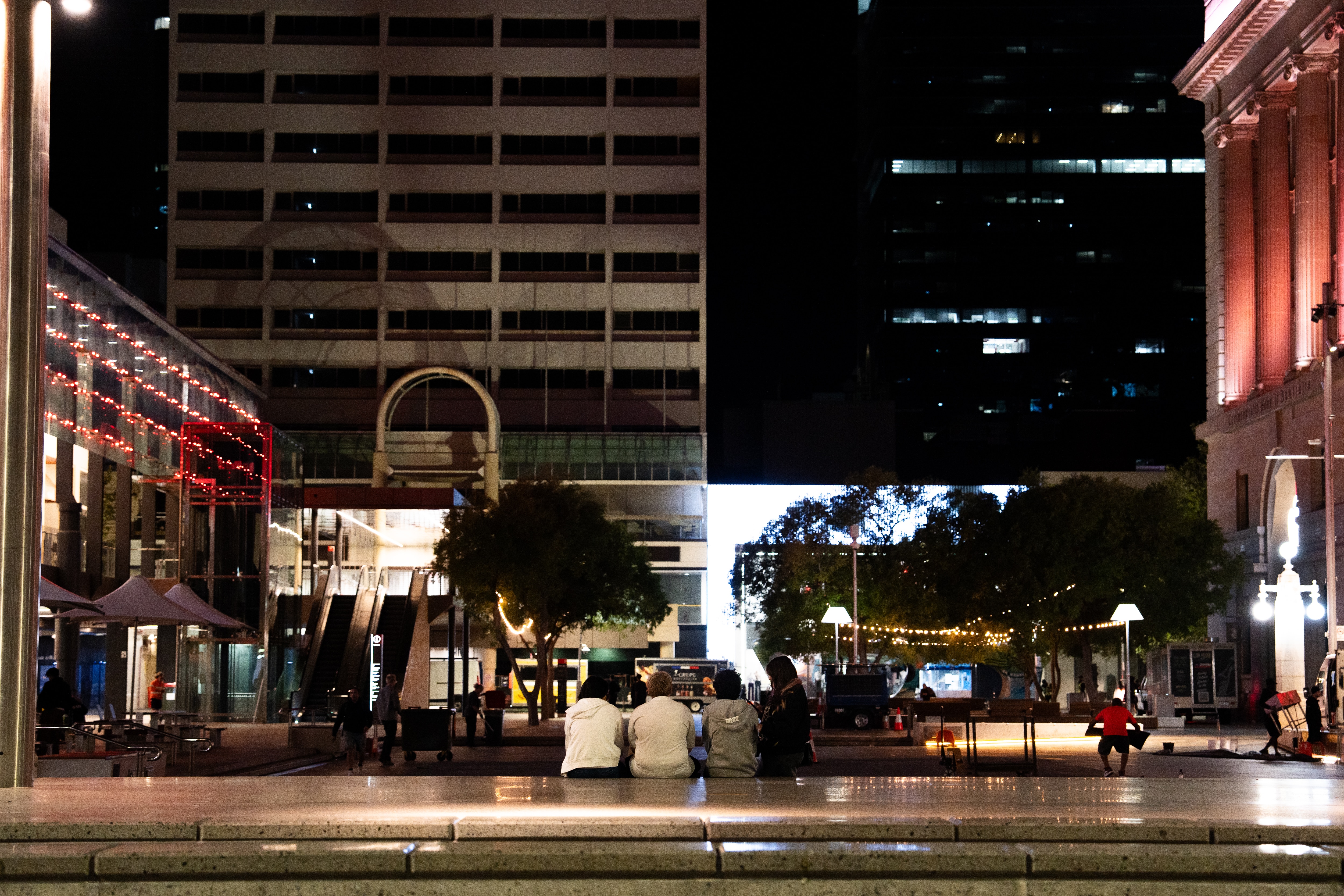A group of youths are seen sitting on the steps of a plaza in Perth