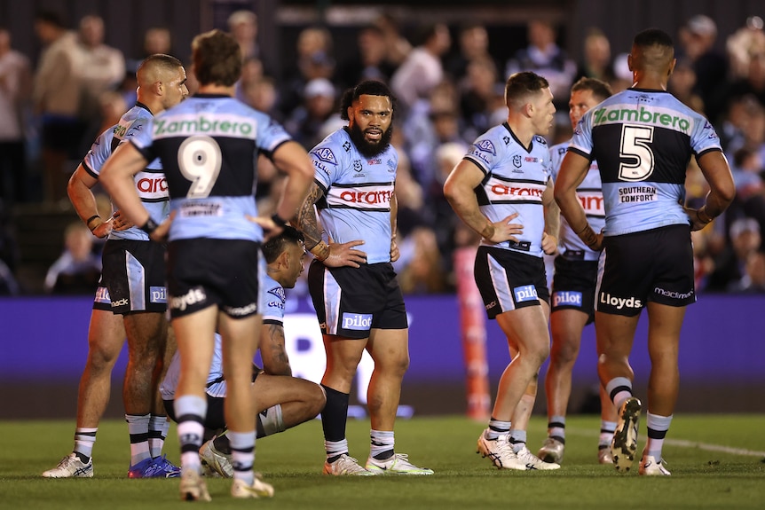 A group of rugby league players look sad after losing a match