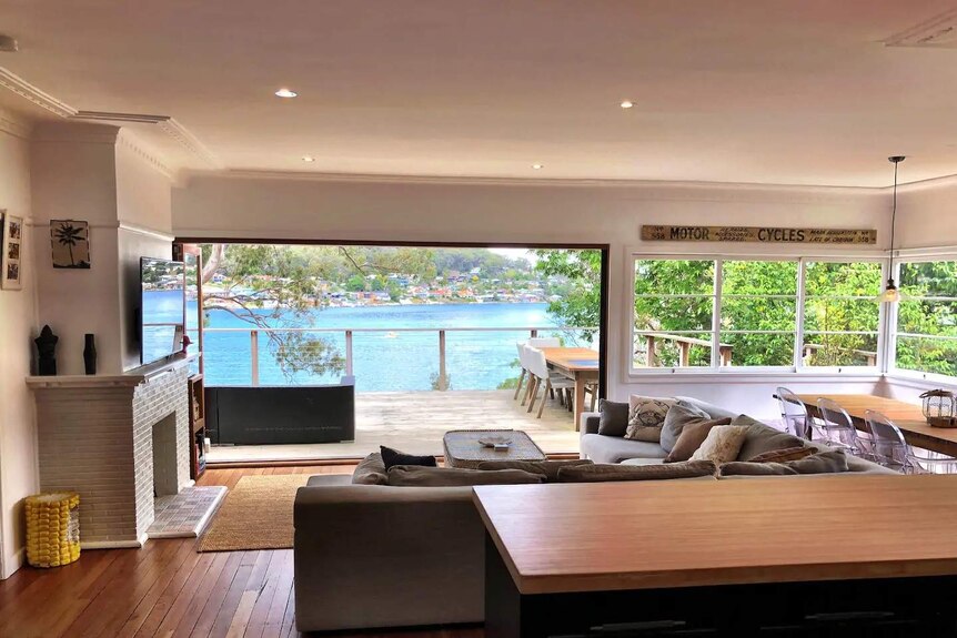 A holiday house with a blue ocean view beyond the windows