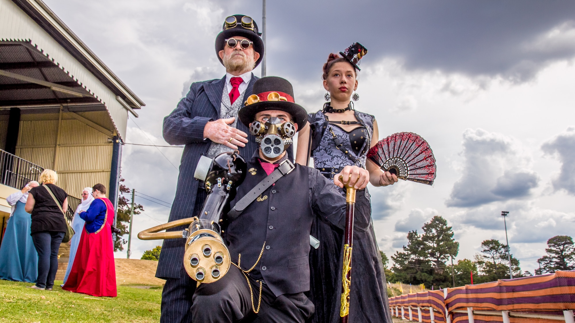 A man and teenaged boy and girl in steampunk costumes