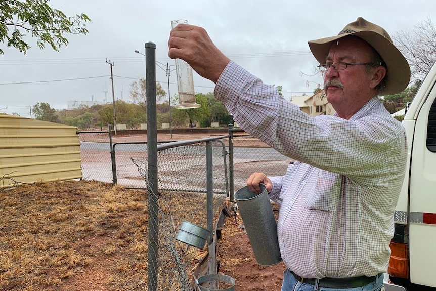 Mike Nash peers at his rain gauge