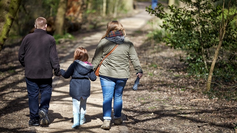 Young family walking in parkland.