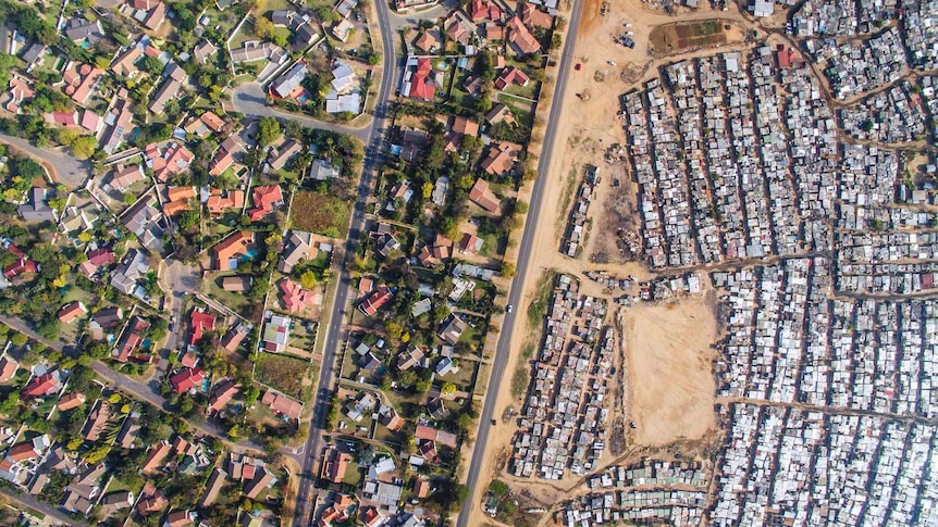 An aerial photo showing a rich neighbourhood and slums side by side