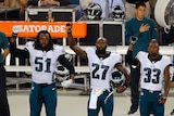 Philadelphia Eagles players raise their fists during the US national anthem