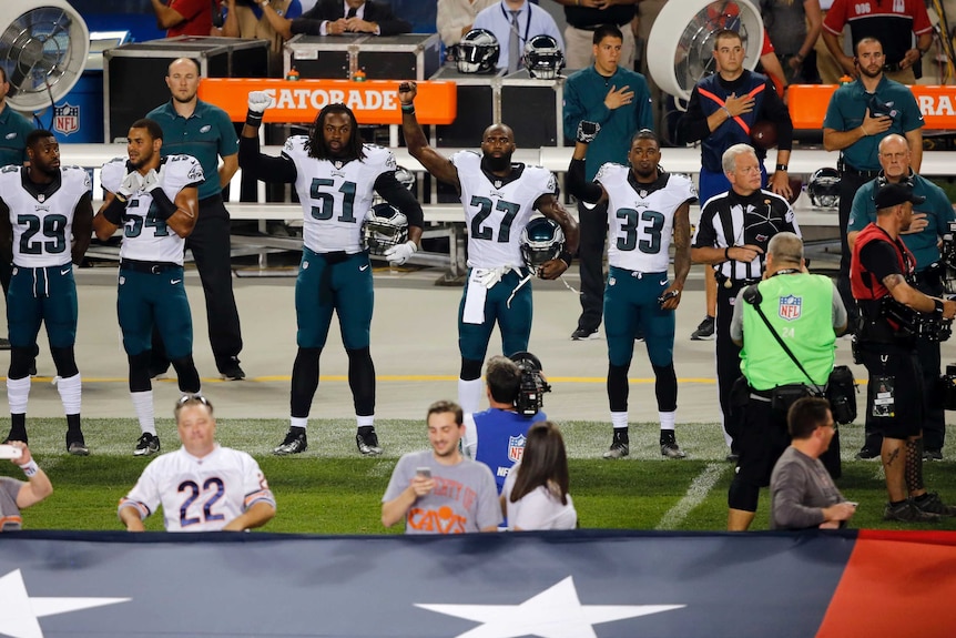 Philadelphia Eagles players raise their fists during the US national anthem