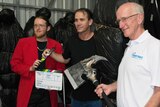 filmmaker Nick Aiton, director Chris Sun and Fraser Coast mayor Chris Loft post with movie props