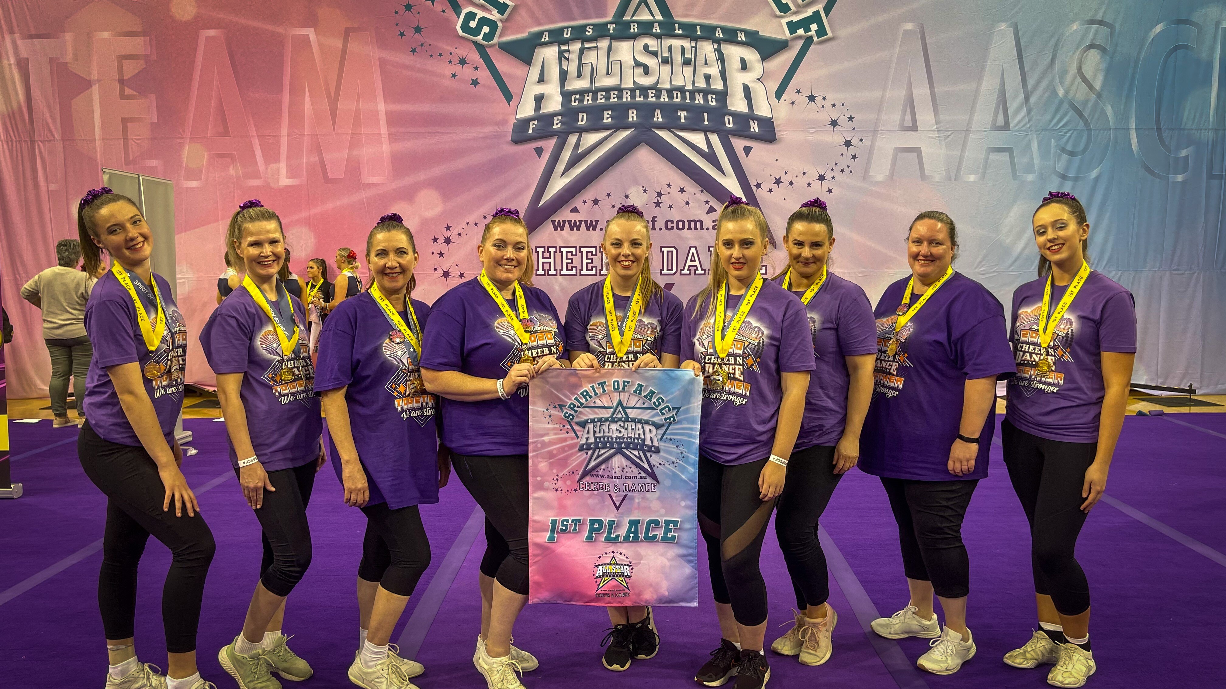 Women standing with first place sign. 