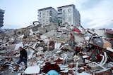People walk amid rubble following an earthquake.