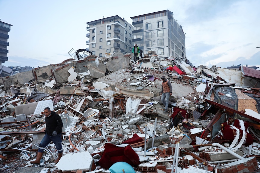 People walk amid rubble following an earthquake.