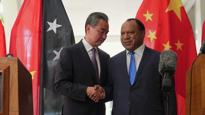 Chinese Foreign Minister Wang Yi (left) shakes hands with PNG's Foreign Minister Rimbink Pato.