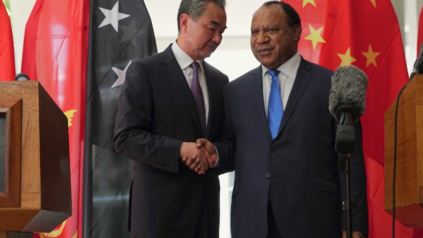 Chinese Foreign Minister Wang Yi (left) shakes hands with PNG's Foreign Minister Rimbink Pato.