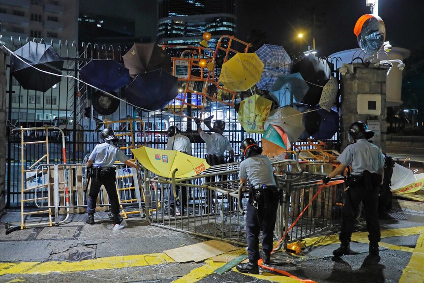 Riot police clear barricades and umbrellas blocked by protesters