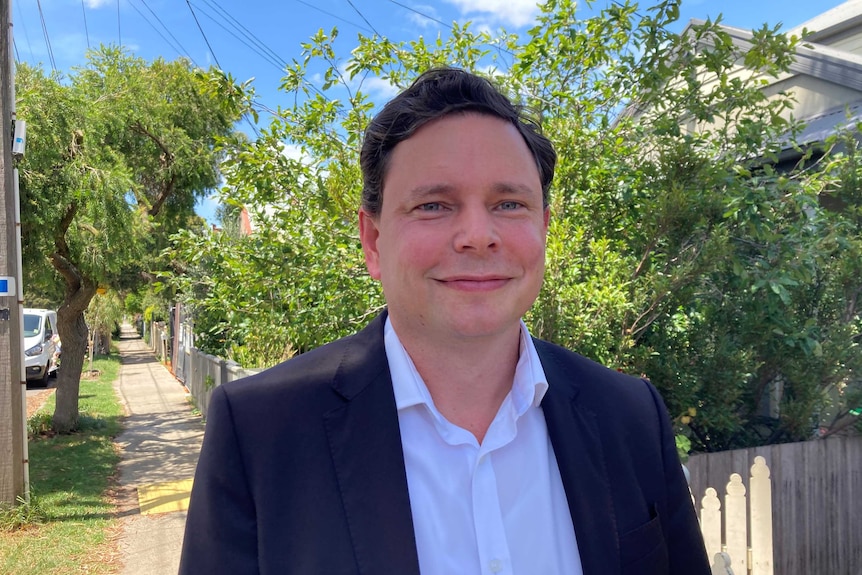 Dugald Murray smiles at the camera on a suburban street.