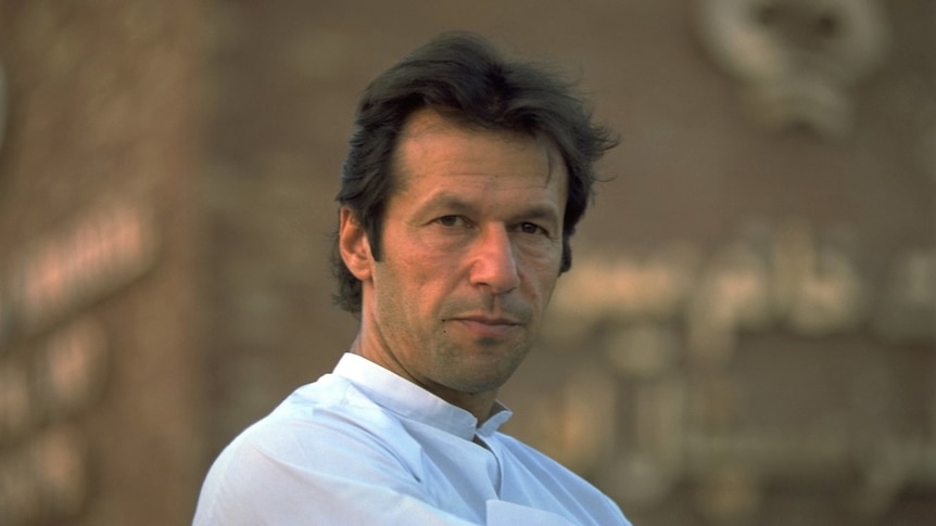 A close up of Imran Khan wearing a white shirt and staring straight ahead.