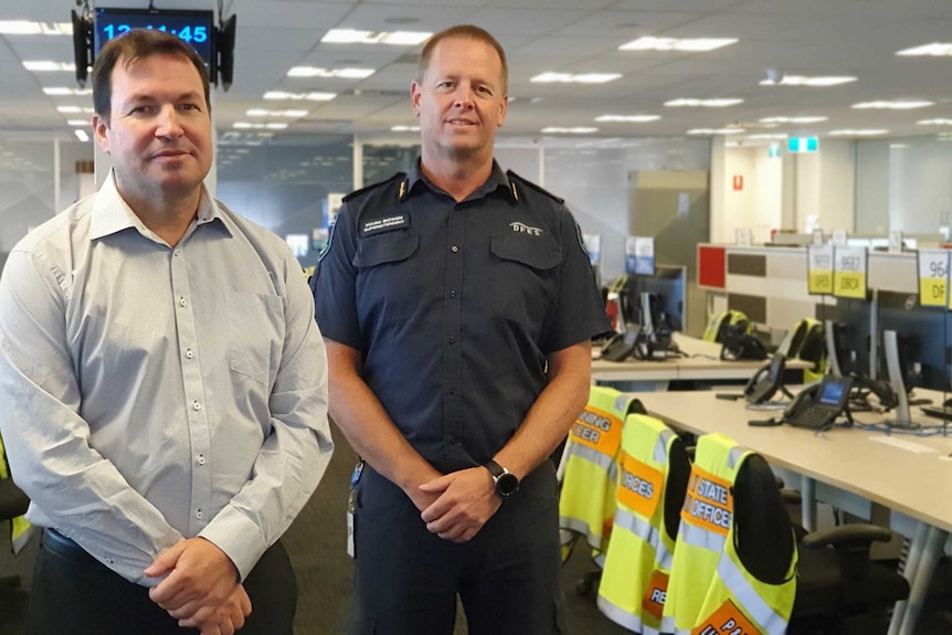 Two men from DFES stand in building between desks