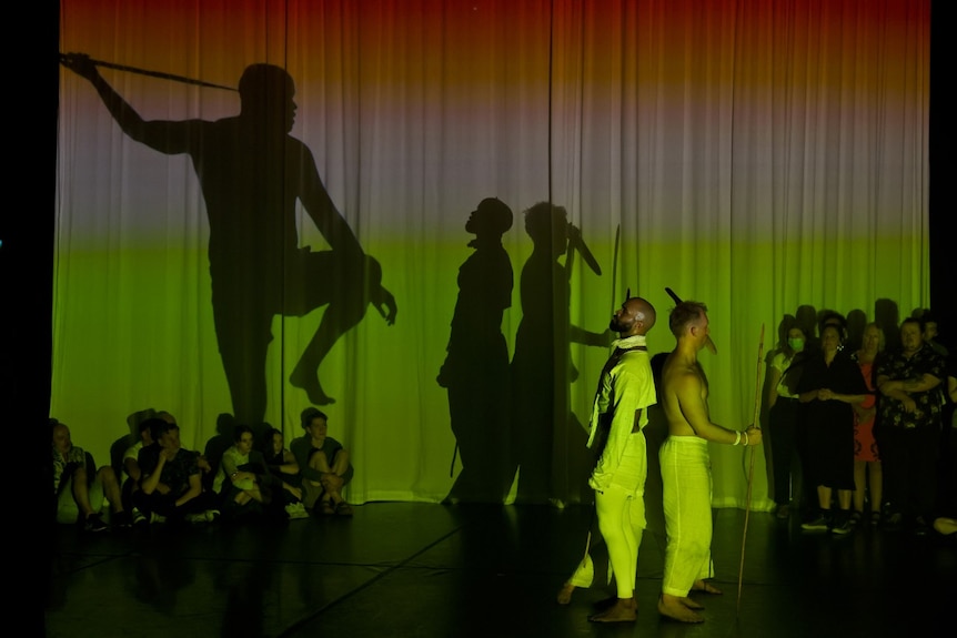 Green shadows,  and three strong Aboriginal men standing together