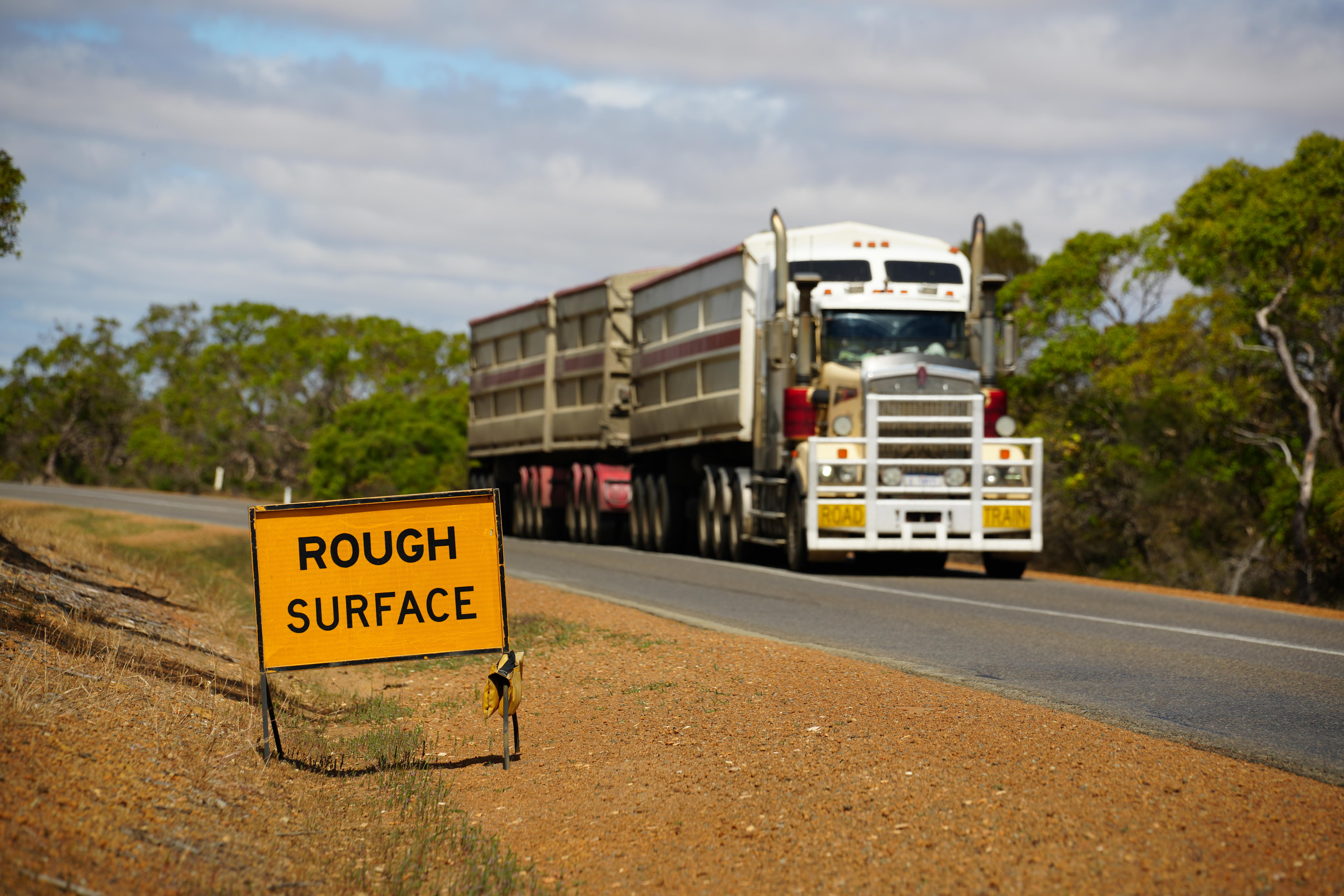 Rough surface road sign on south coast highway which is an essential heavy haulage road.