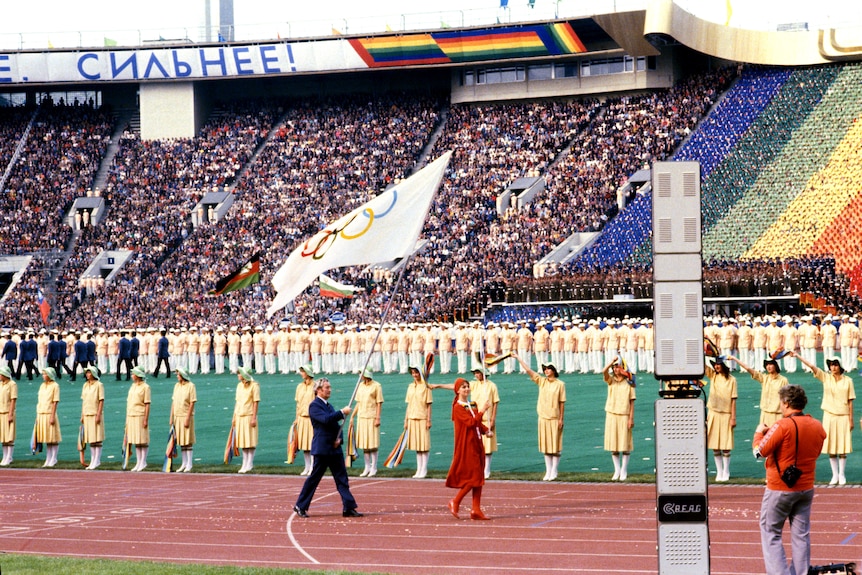 Dick Palmer, Great Britain's chef de mission, carries the Olympic flag in the opening ceremony of the Moscow Olympics in 1980.