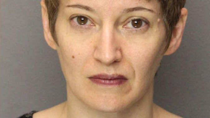 A mugshot of an unsmiling woman with short hair.