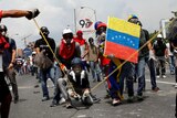 Opposition supporters use a giant sling shot to throw a "Poopootovs".