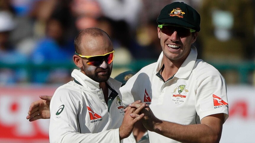 Nathan Lyon and Pat Cummins celebrate a wicket for Australia on day two
