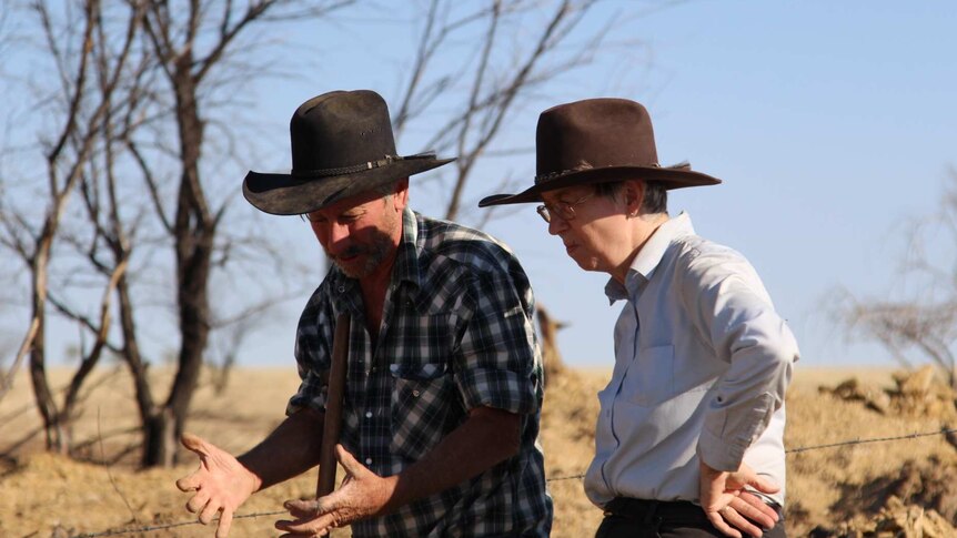 Two people wearing wide-brimmed hats in the outback near Winton, Queensland in 2018.