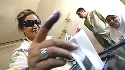 An Iraqi woman casts her vote in the referendum on the constitution.