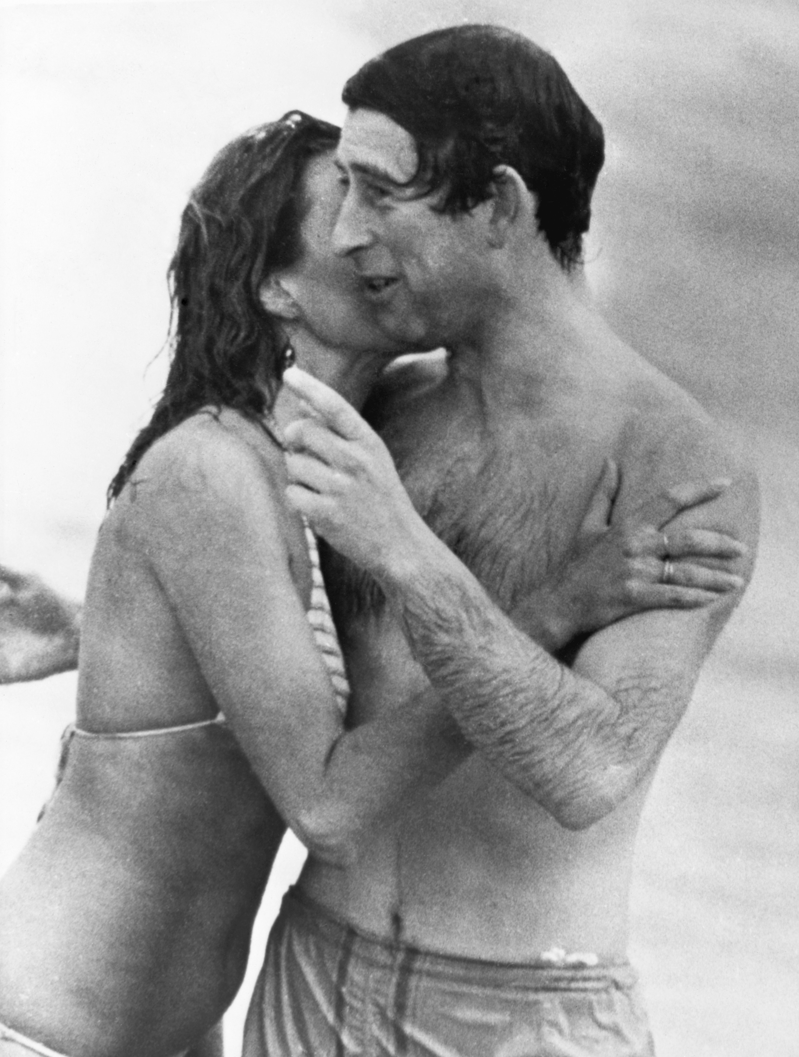 Prince Charles is kissed by a woman wearing a bikini as he emerges form the water at a Perth beach.