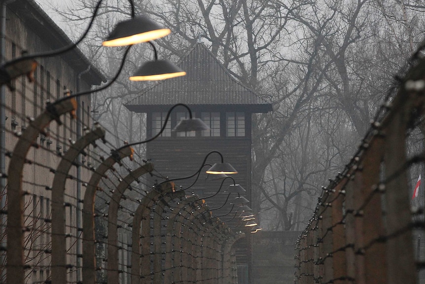 Barbed wire fences at the Auschwitz concentration camp on and overcast day.