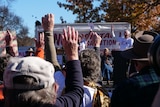 A crowd cheers at a rally.