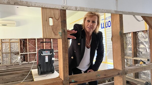 Middle aged woman looking through her flood-ruined home