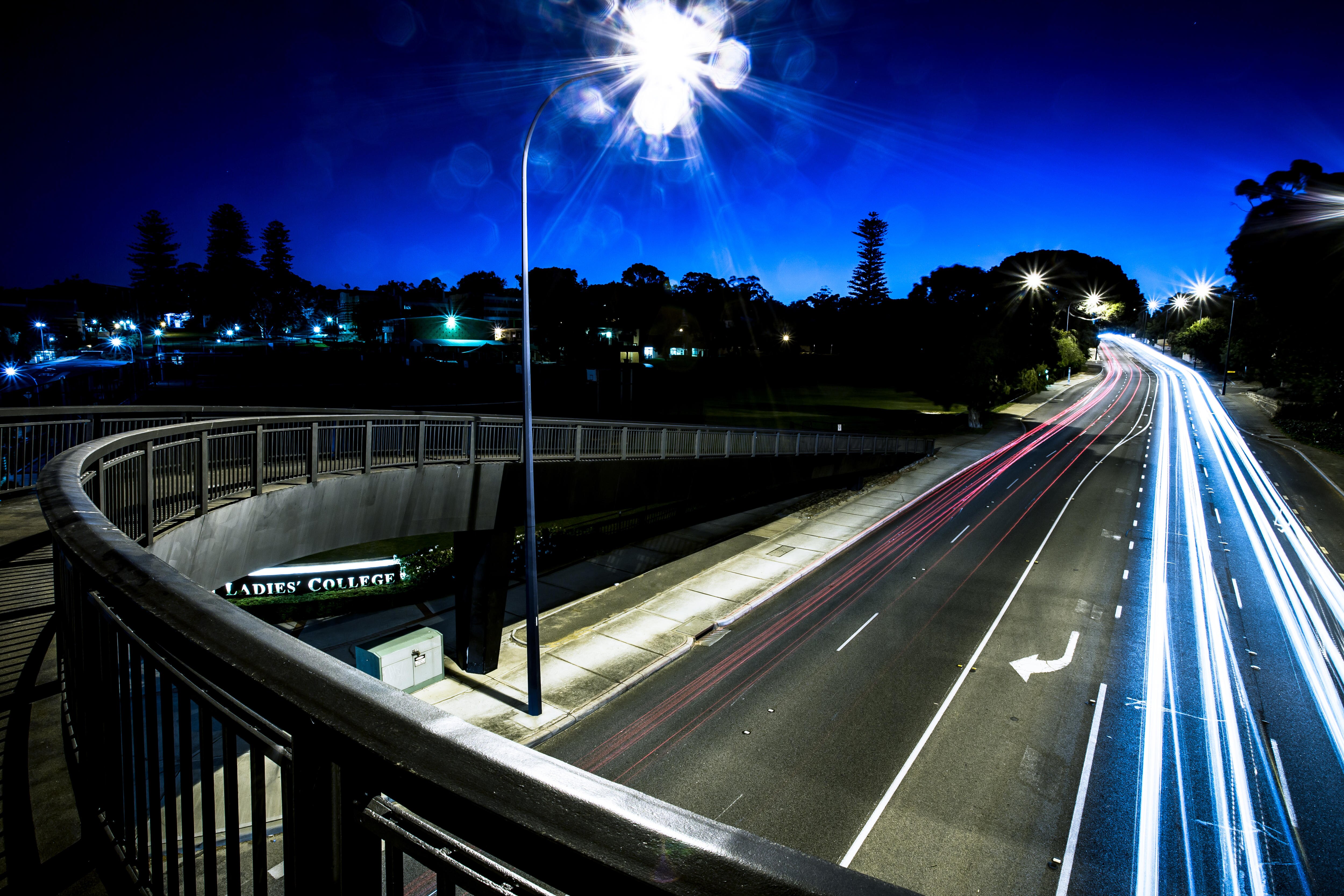 Street lights and car lights glow in a night scene