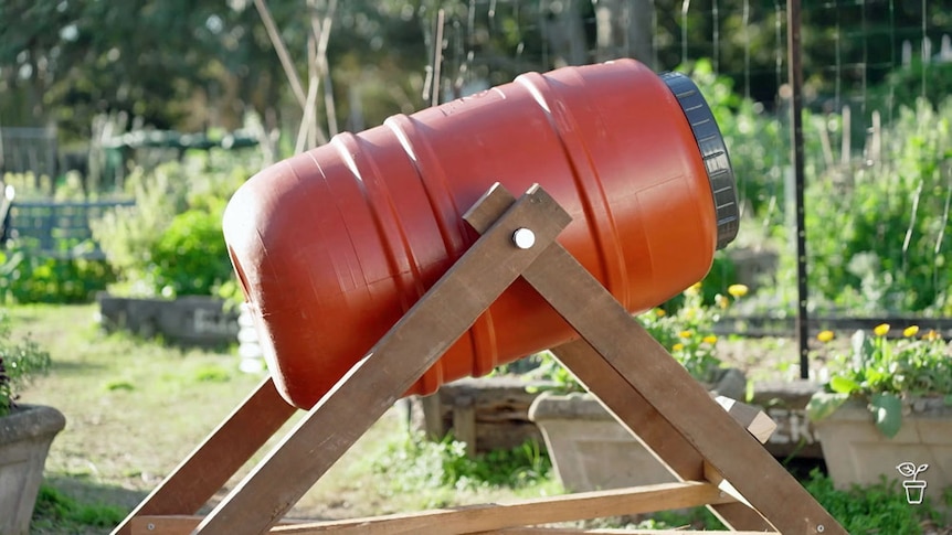 A homemade compost spinner in a vegetable garden.