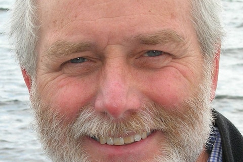 Portrait of an older man with a short beard and grey hair.