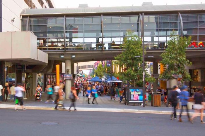 Busy Wollongong Crown Street Mall with many pedestrians walking shopping on a market day and people walking across the street.