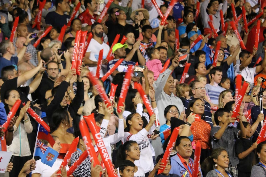 Crowd at Pacific Games cheers and wave blow-up batons'
