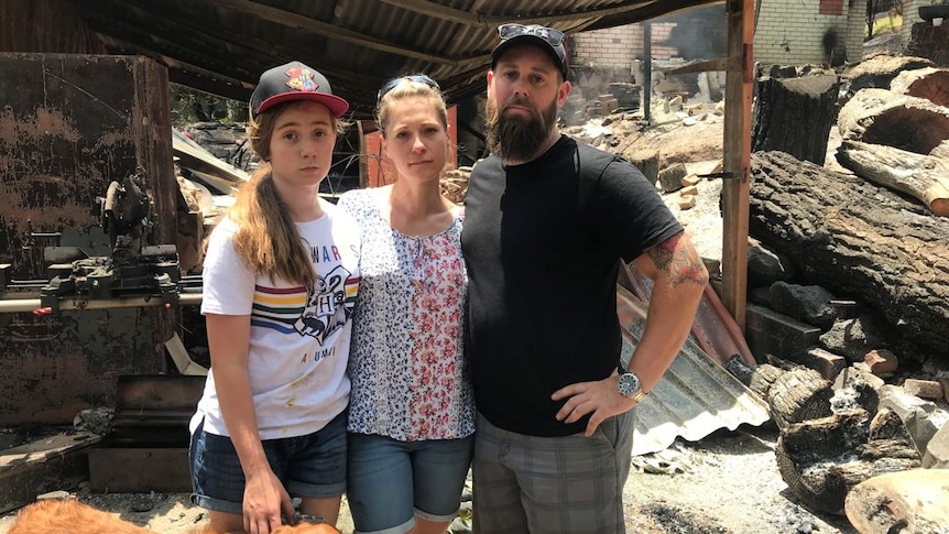 Estelle, Rhiann and Marc Webb stand amongst rubble.