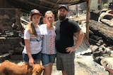 Estelle, Rhiann and Marc Webb stand amongst rubble.