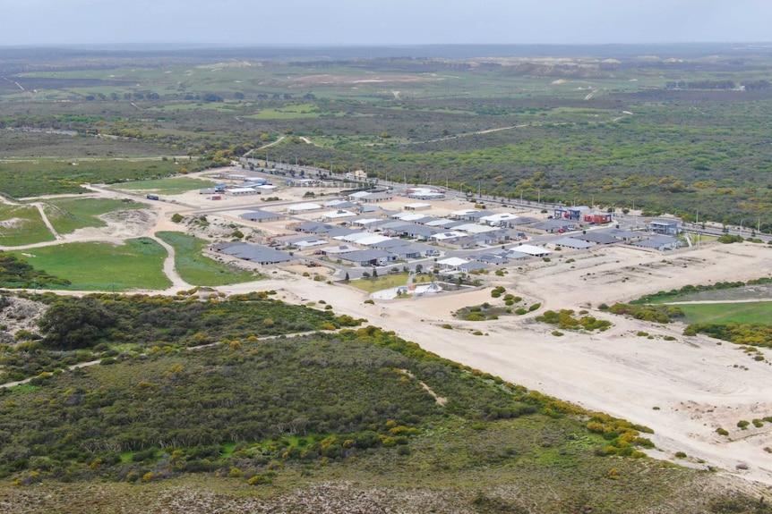 An aerial shot of a housing division surrounded by undeveloped land