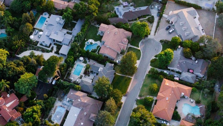 Birds eye view of houses with swimming pools