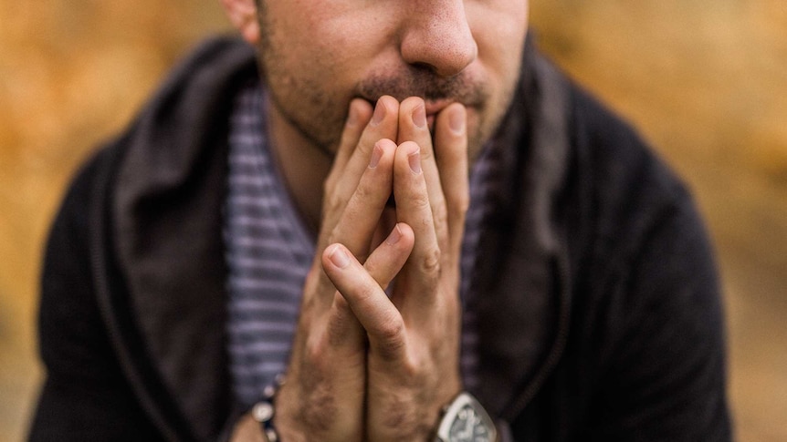 Man thinks with this hands over his mouth for a story about how being an anxious person prepares you for times like coronavirus.