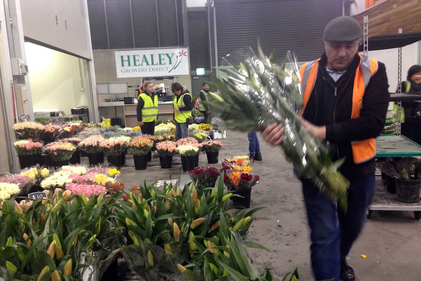 Man with flowers inside Melbourne Market