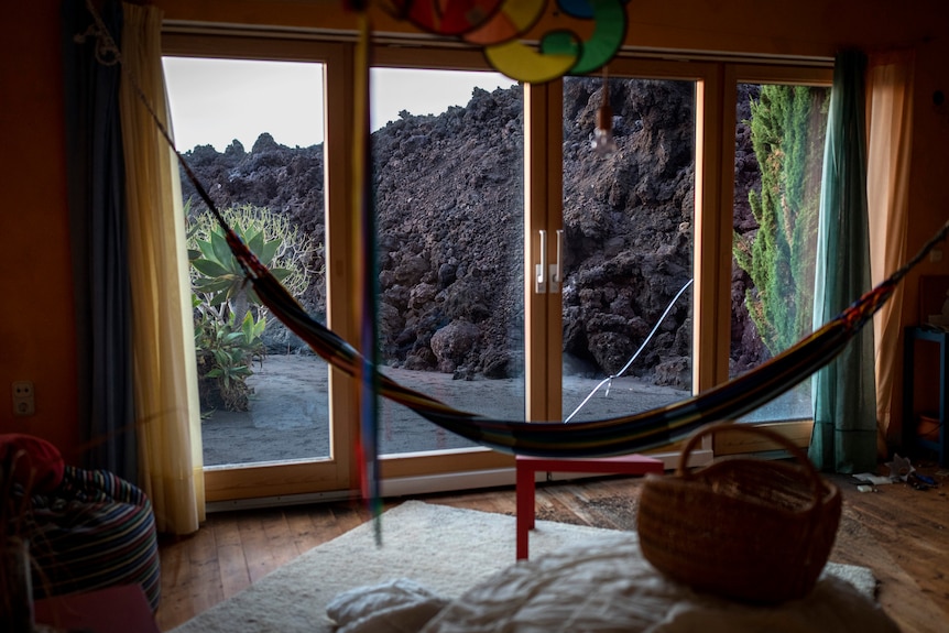La lave d'un volcan avance vers une maison.