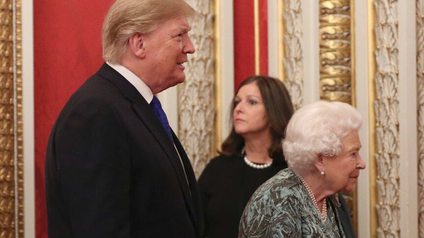Donald Trump walks behind Queen Elizabeth II at Buckingham Palace