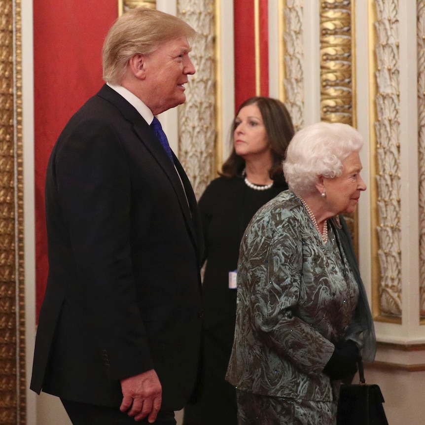 Donald Trump walks behind Queen Elizabeth II at Buckingham Palace