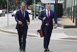 Queensland Reds star Karmichael Hunt walks across the road towards Brisbane court with lawyer Adam Magill