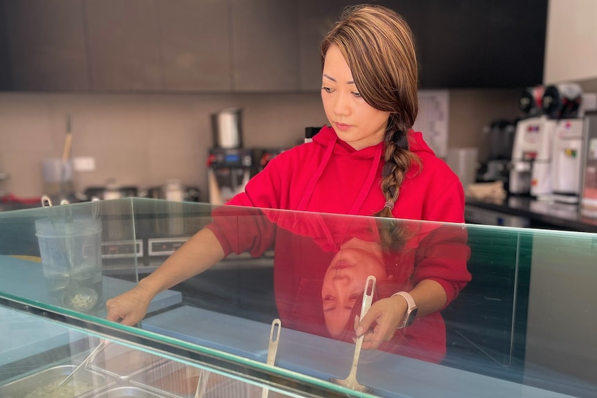 A woman stands behind a counter