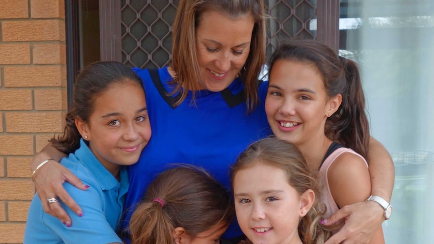 ACT Barnardos Mother of the Year Belinda Nunn receives a hug from her children.