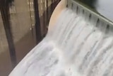 A large concrete mass with water pouring over it